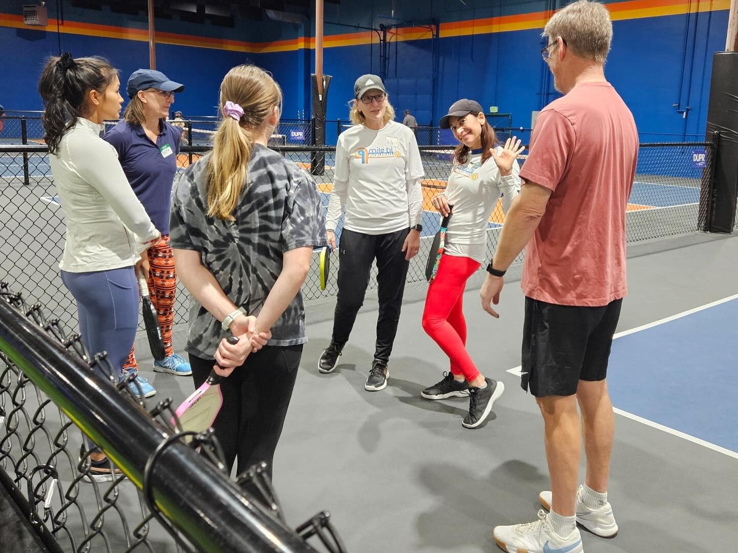 Karen coaching a small group on the court at Mile Hi Pickleball